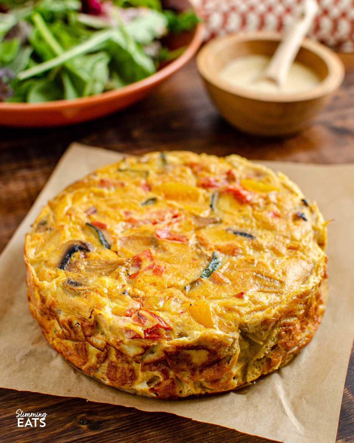 Enjoy a delicious and healthy alternative to the classic quiche. This dairy free crustless bacon vegetable quiche is packed with protein and flavourful vegetables and is perfect for those who need to avoid dairy. Dairy Free Crustless Bacon and Vegetable Quiche on parchment paper