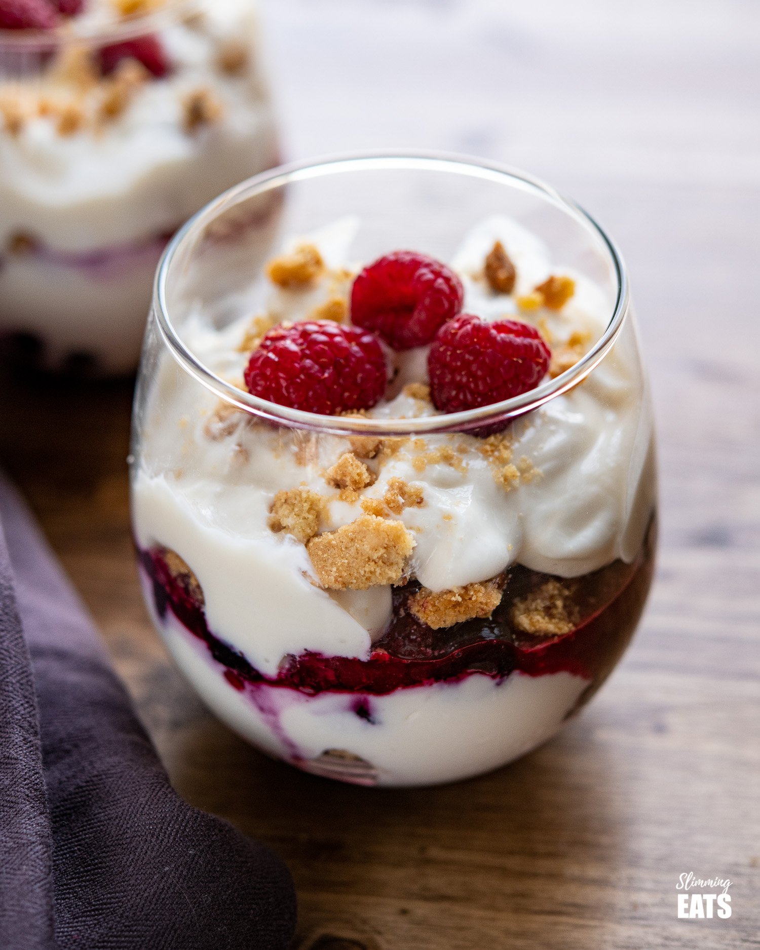 Fruity Yoghurt Shortbread Sundae in stemless wine glass with aubergine coloured napkin to the left 