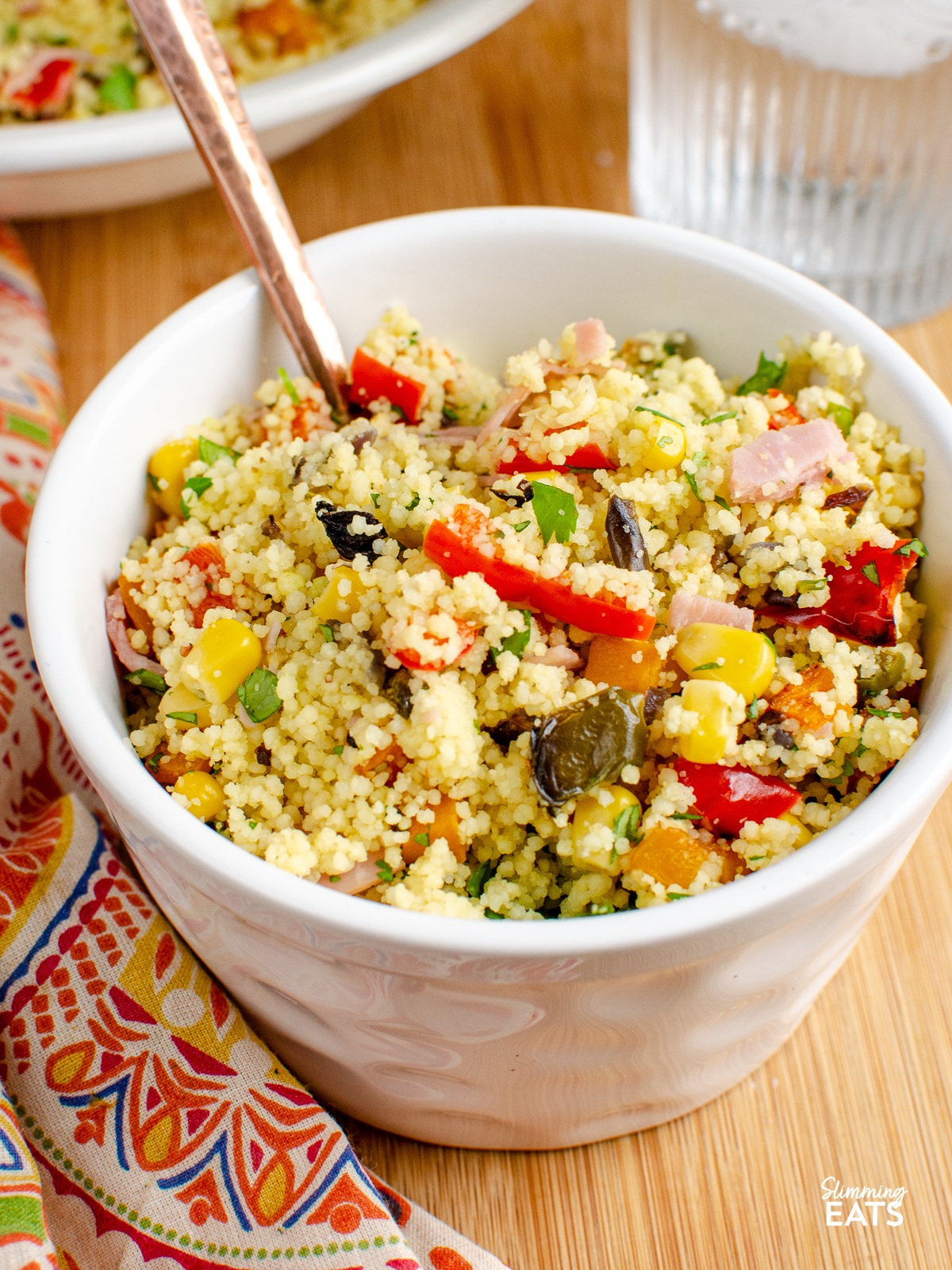 serving of Roasted Vegetables and Ham Couscous in white bowl 