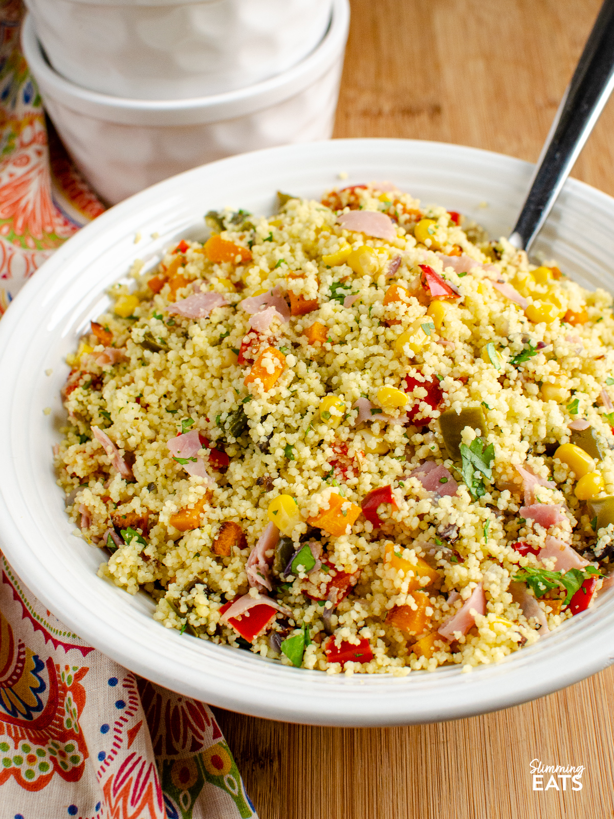 Roasted Vegetables and Ham Couscous in a large white bowl with spoon