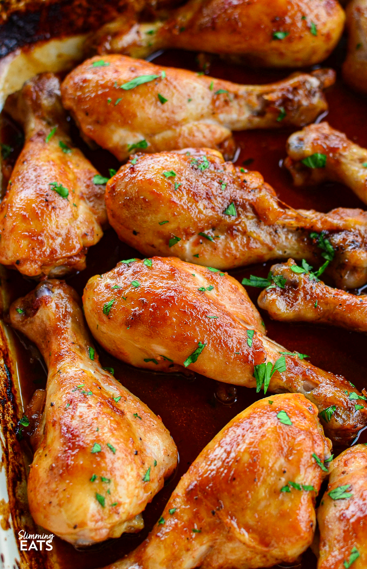 close up of Cooked Maple Glazed Chicken drumsticks in a baking dish