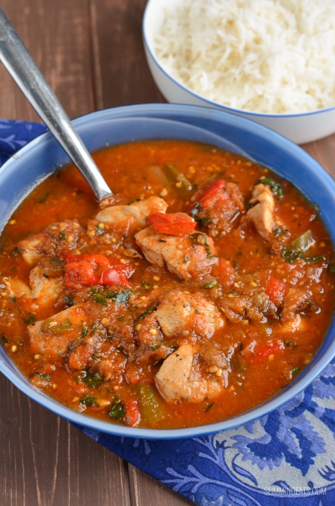 Mediterranean Chicken Chicken Casserole in a blue bowl with rice in a white bowl in background