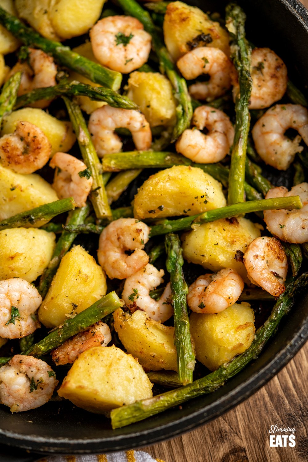 close up of warm asparagus and prawn salad in frying pan