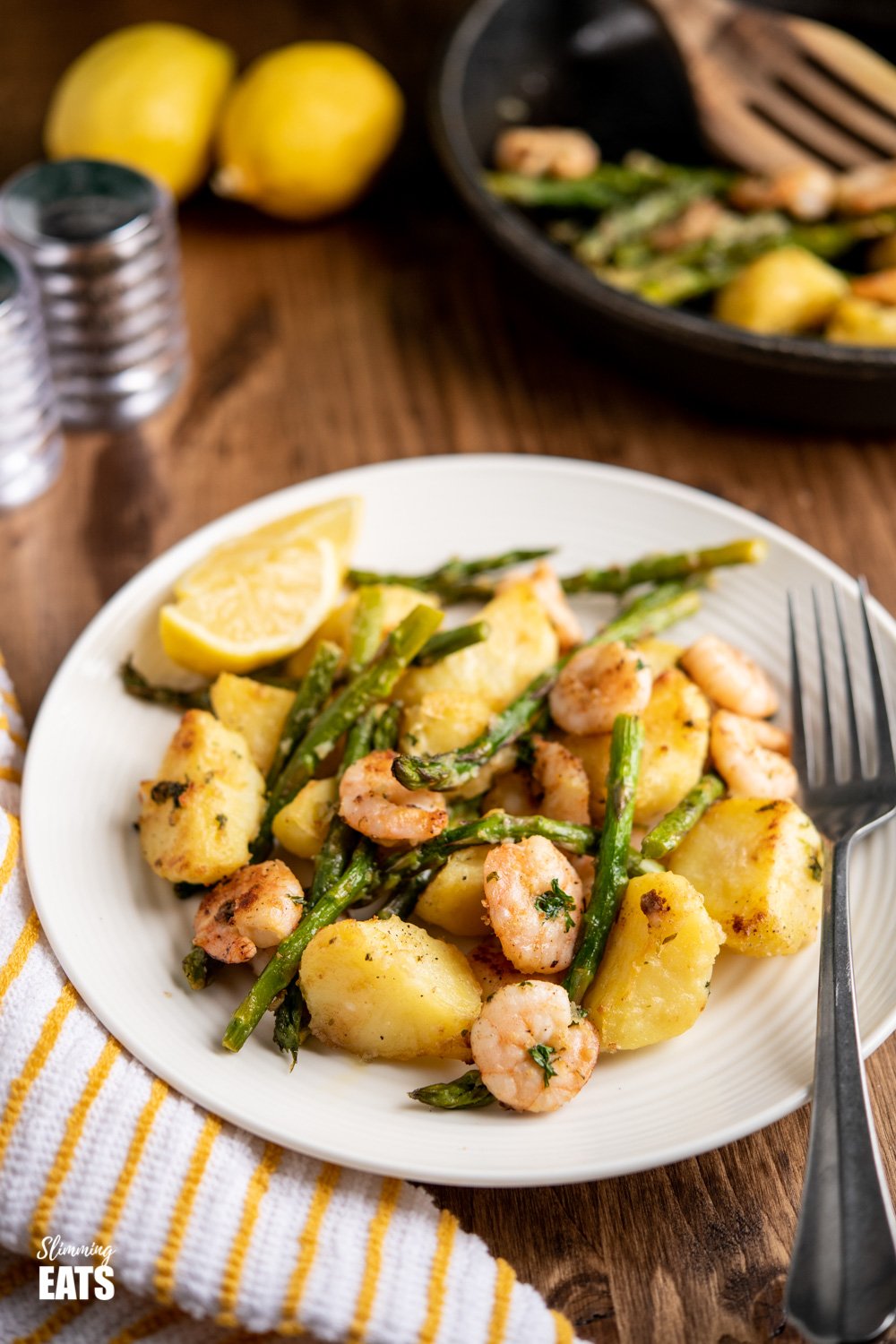 warm asparagus and prawn salad on white plate with fork