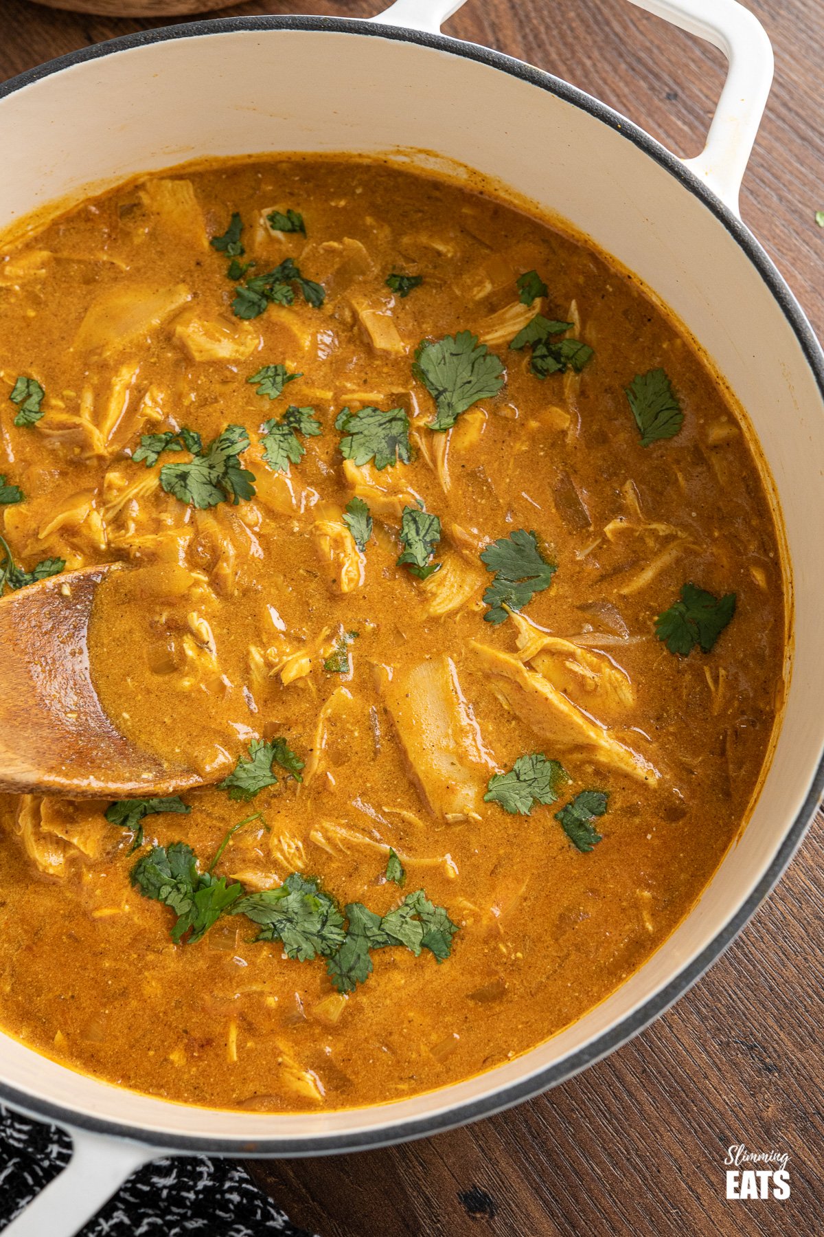 Quick Mild Chicken Curry (from www.slimmingeats.com) - a delicately flavoured curry using chicken and yoghurt for a perfect family meal any night of the week. #chicken #curry #slimming #weightwatchers #glutenfree close up of mild chicken curry in white cast iron pan