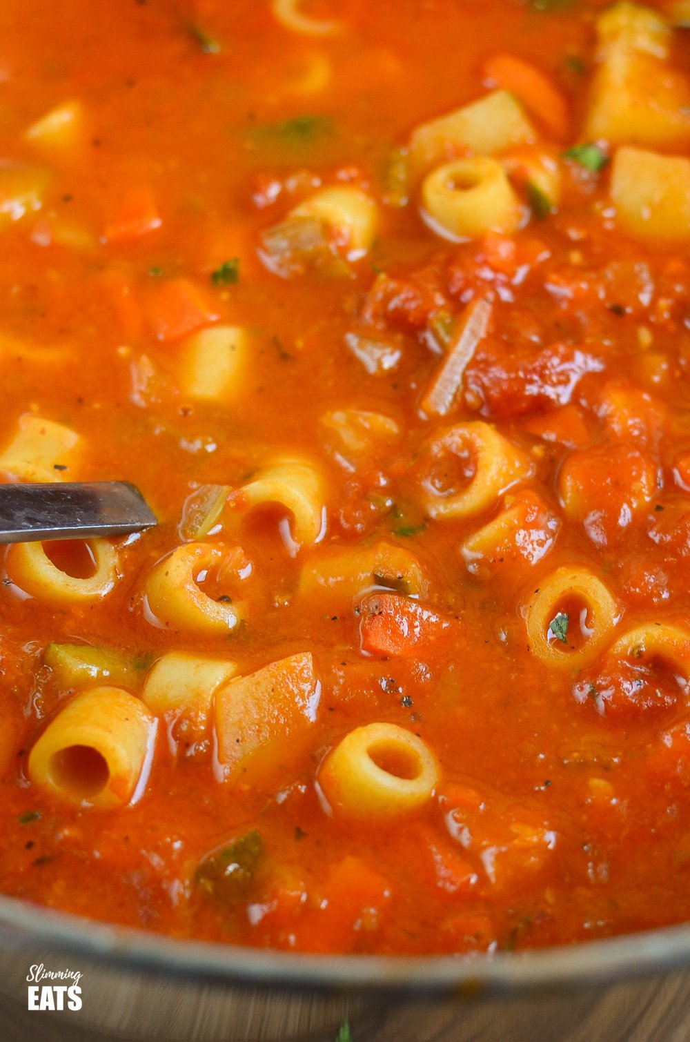 close up of minestrone soup in saucepan