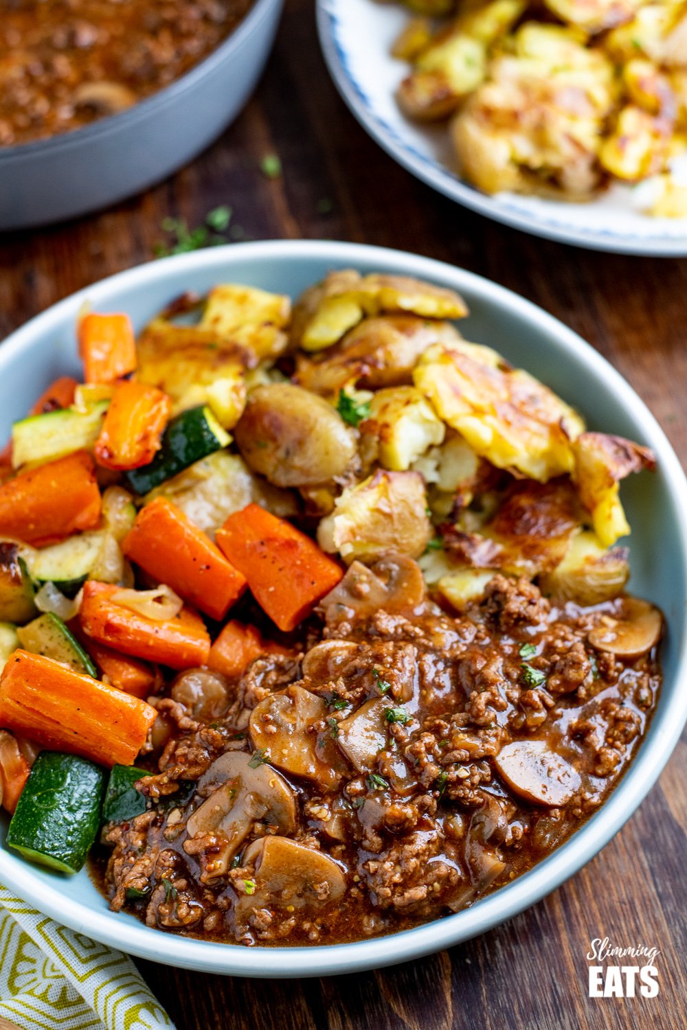 blue plate with mustard beef, potatoes and vegetables