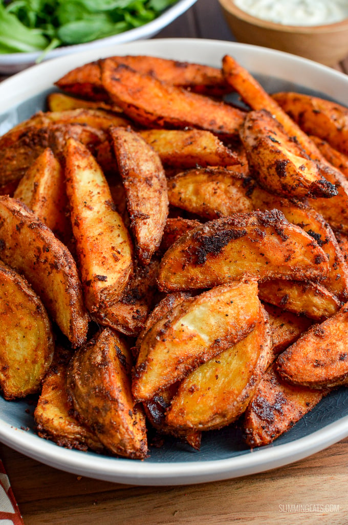 Add a spicy kick to your main course, with this delicious and healthier oven-baked Syn Free Spicy Potato Wedges - yum!! Gluten Free, Dairy Free, Vegetarian, Slimming World and Weight Watchers friendly | www.slimmingeats.com