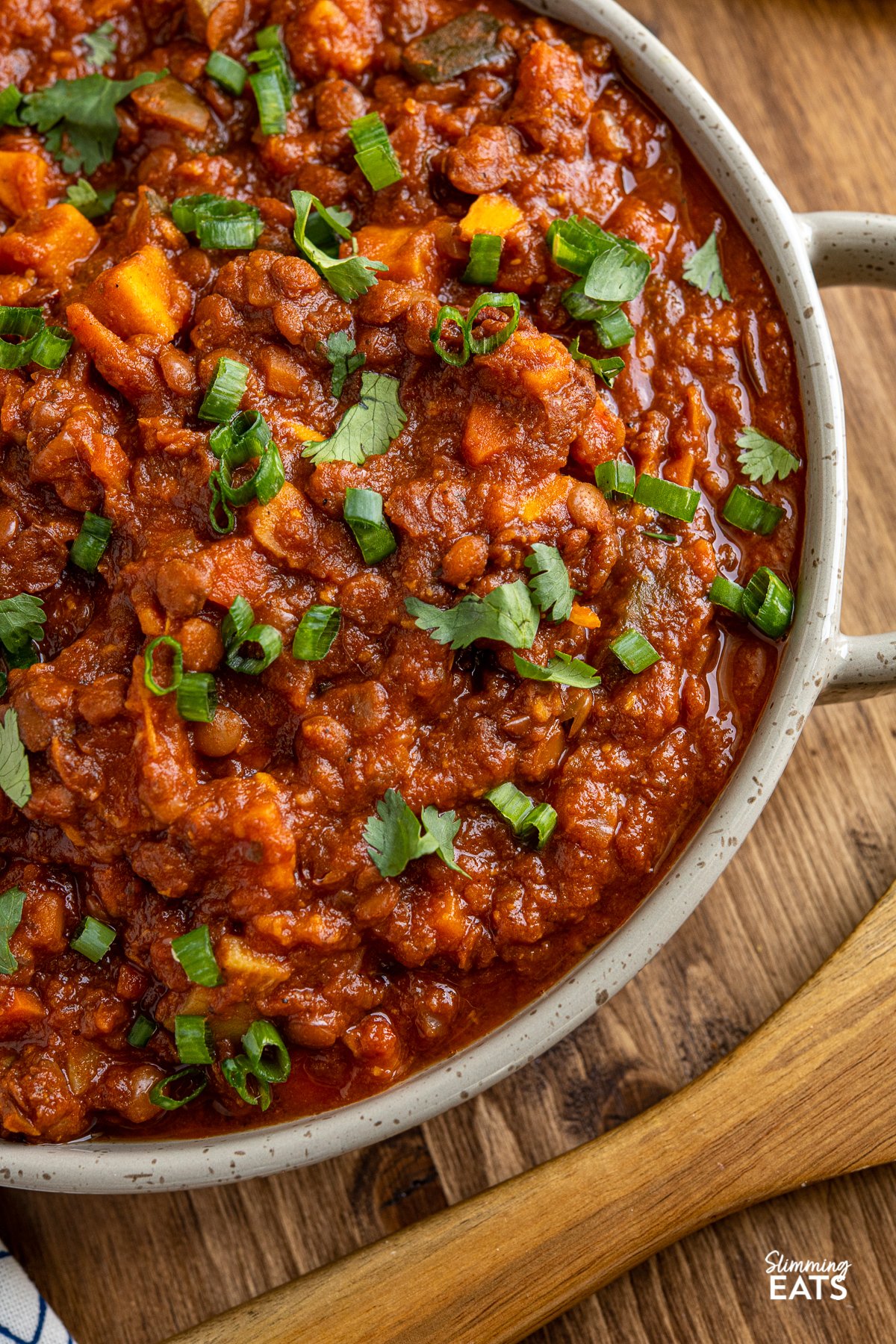 close up of Sweet Potato, Vegetable and Lentil Chilli in a brown grey double handled dish