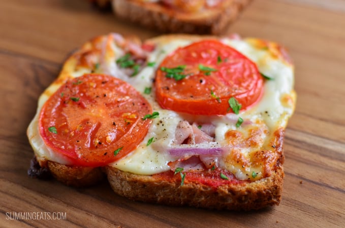Pizza Toasts - crispy toast base smothered with pizza sauce and melted cheesy goodness. #slimmingeats #weightwatchers #pizza #bread close up of pizza toast on a wooden board