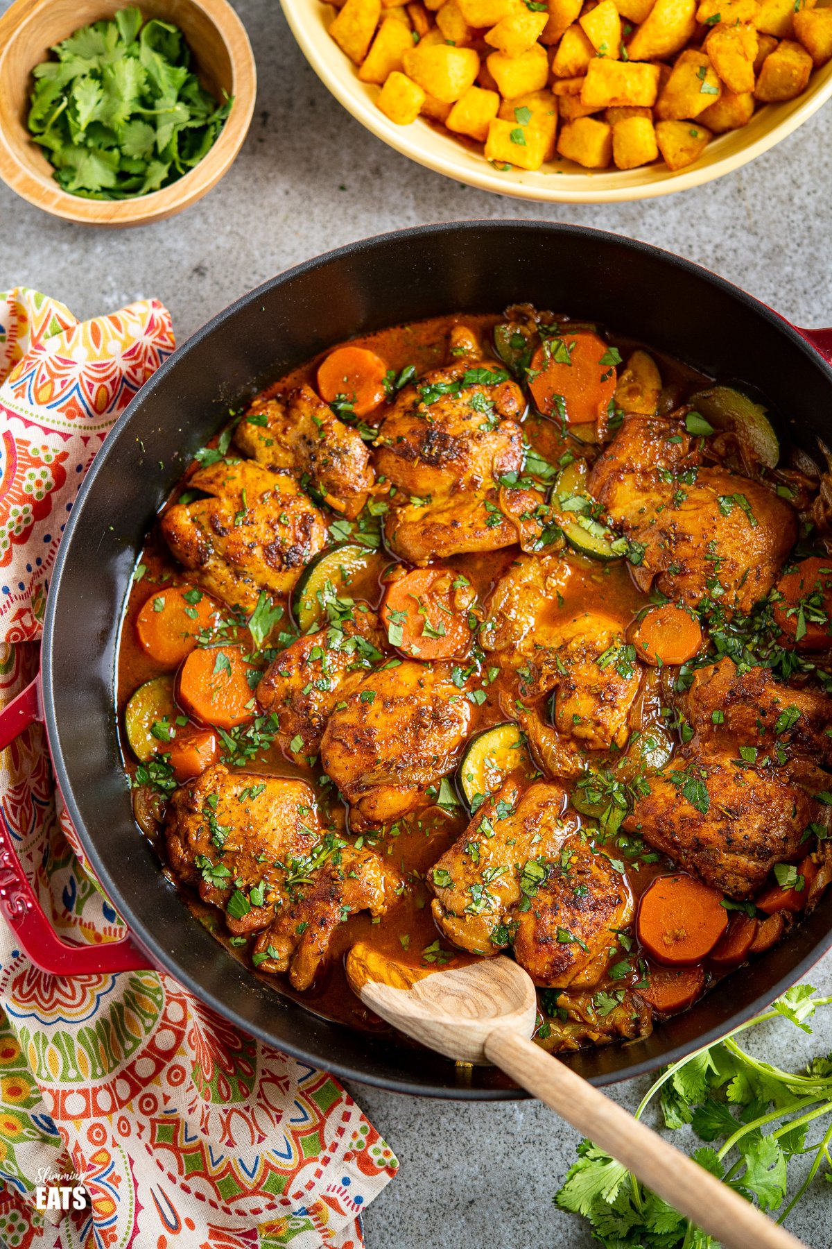 Moroccan Chicken Casserole - Delicious hearty and wholesome casserole with the lovely flavours of Moroccan inspired spices. Moroccan Casserole in cherry cast iron staub dish with turmeric potatoes in yellow dish