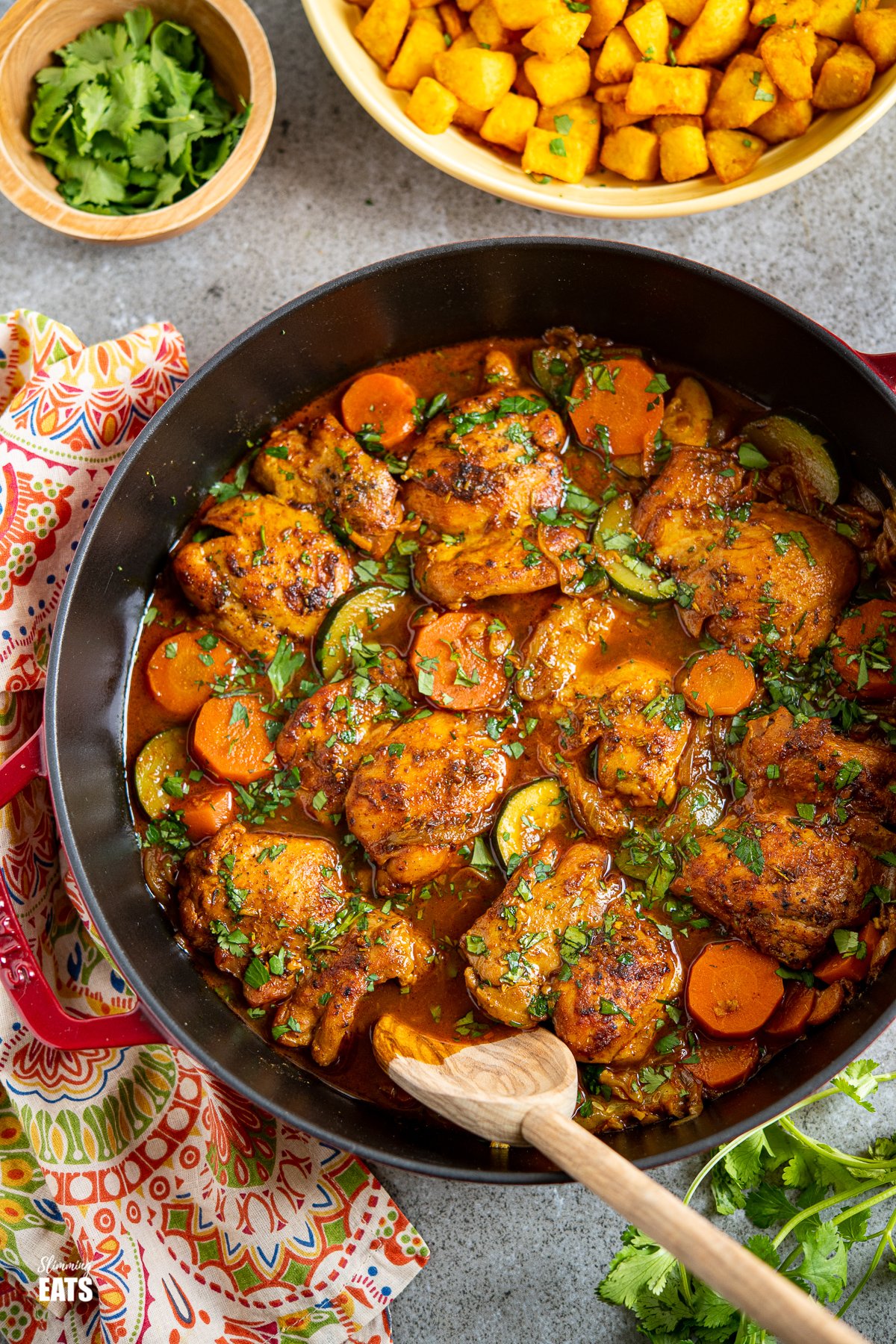 Moroccan Casserole in cherry cast iron staub dish with turmeric potatoes in yellow dish