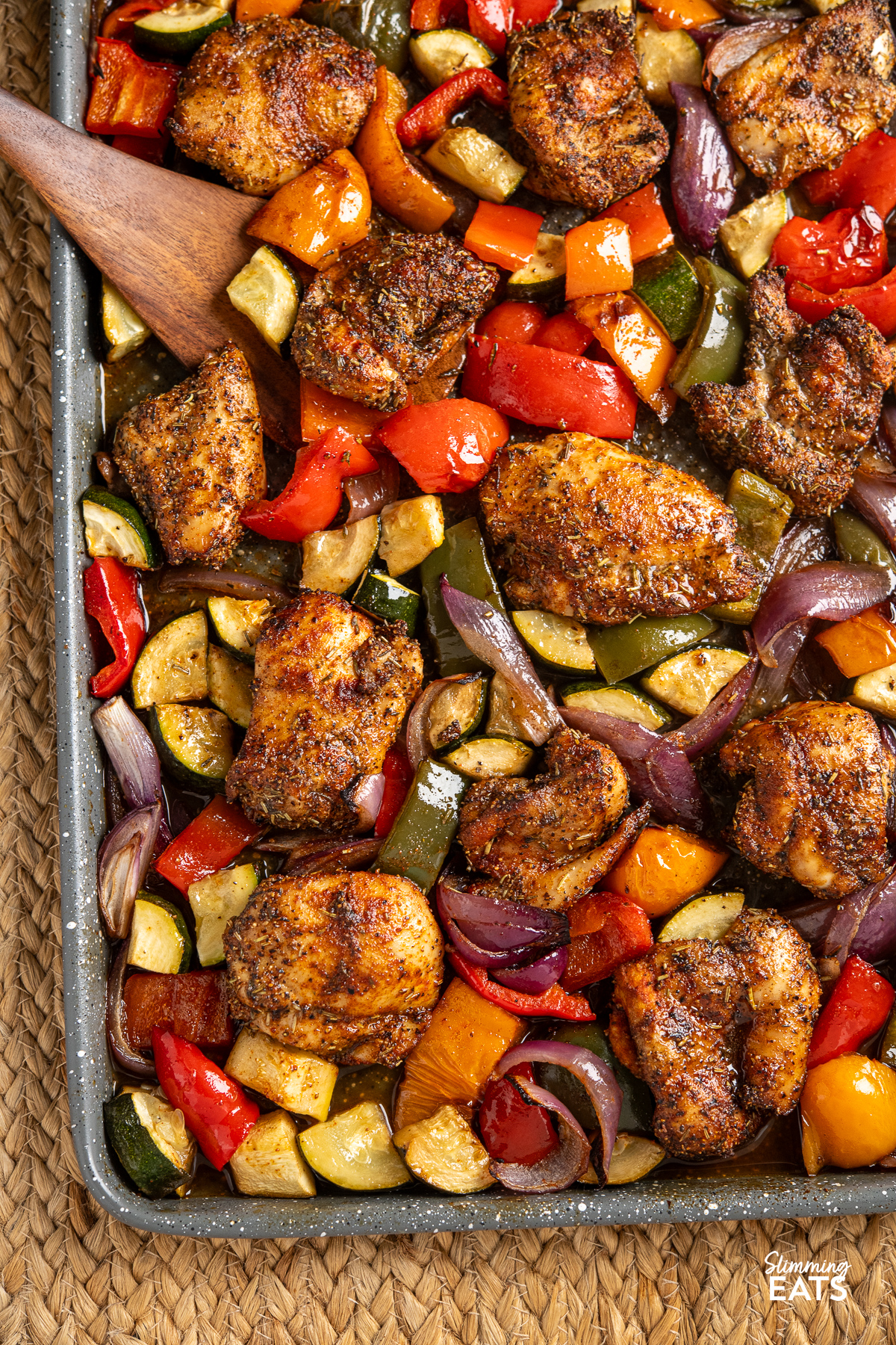 close up of Black pepper chicken with balsamic roasted vegetables arranged on a baking tray.