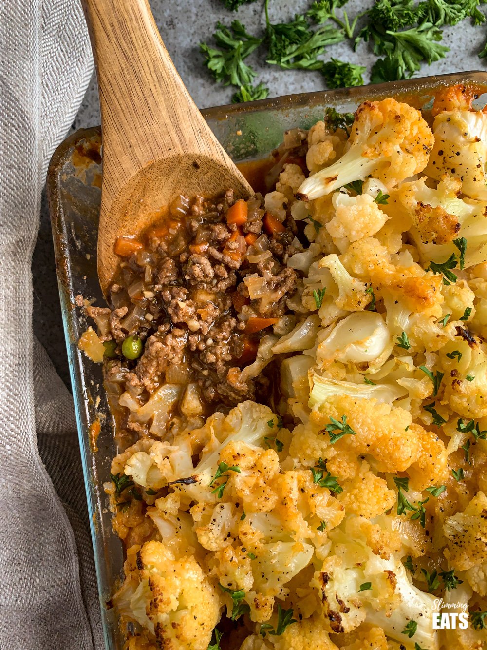 Cheesy Cauliflower Topped Pie - all the goodness of a traditional cottage pie but topped with delicious tender cheesy cauliflower florets. Gluten free, Slimming Eats and Weight Watchers friendly close up of wooden spoon in Cheesy Cauliflower Topped Pie