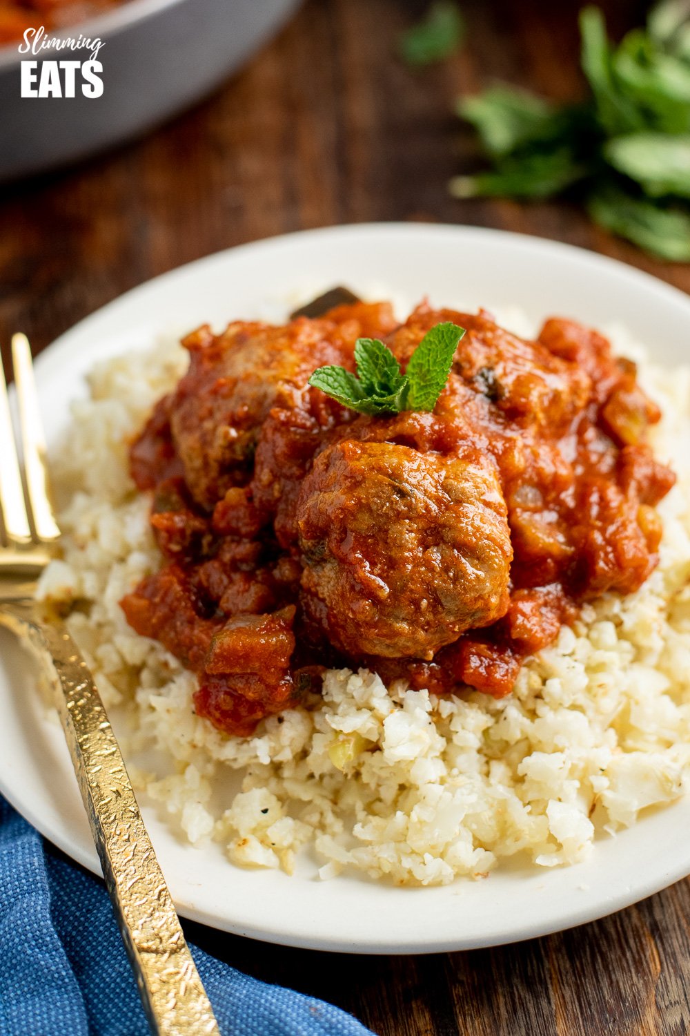 Tender Lamb and Mint Meatballs in a sweet and spicy sauce packed with healthy vegetables. #glutenfree #paleo #dairyfree #eggs #lamb #meatballs #slimming #weightwatchers close up of lamb and mint meatballs on a white plate with cauliflower rice
