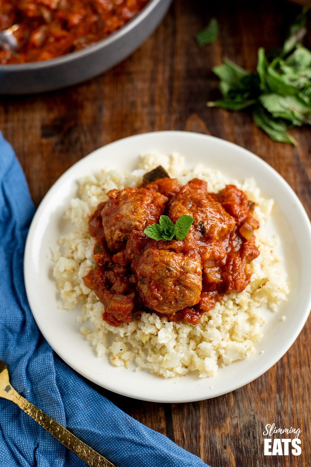 lamb and mint meatballs in a sweet and spicy sauce with cauliflower rice on a white plate