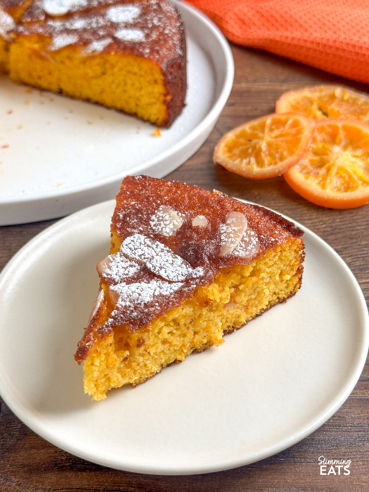close up of a slice of Clementine Orange Almond Cake on a cream plate