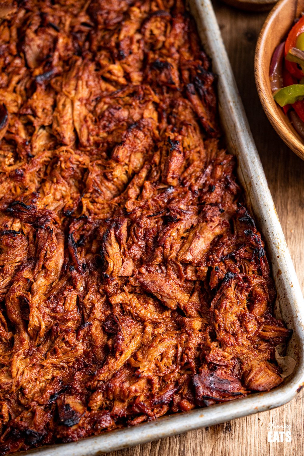 close up of slow cooker pulled pork caramelised on baking tray