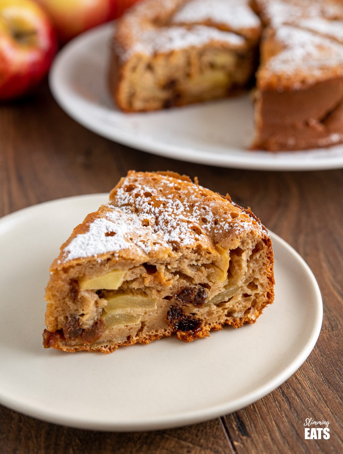 close up of slice of apple sultan cake on white plate