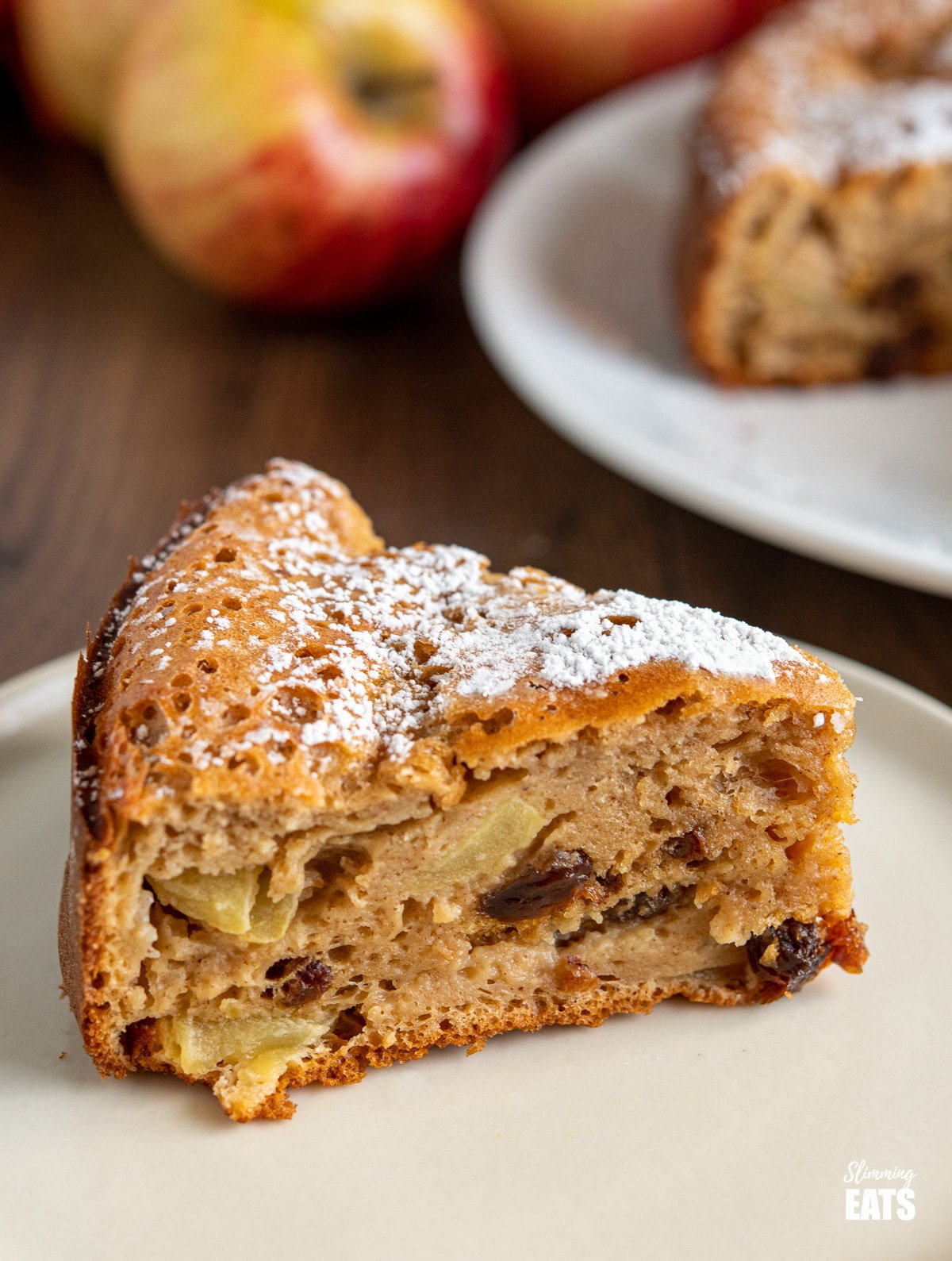 Apple and Sultana Cake (from www.slimmingeats.com) - a light healthier cake with fresh apples, sultanas and a hint of spices. #slimmingworld #weightwatchers #cake #apple #sultanas close up of sultana apple cake on plate