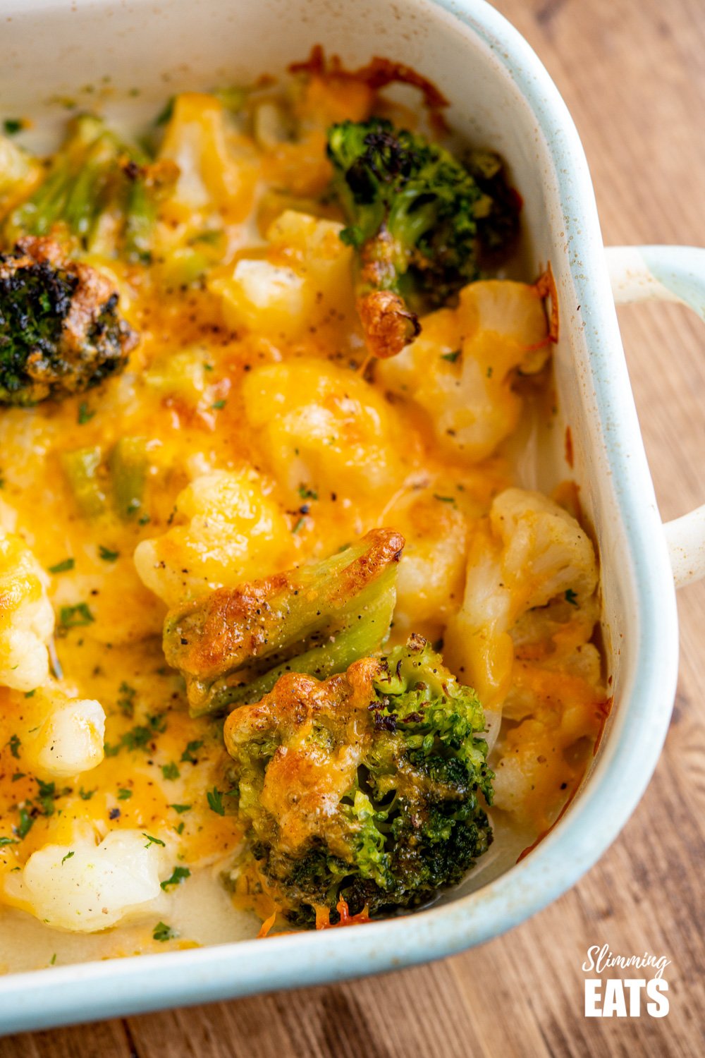 close up of Creamy Cheesy Vegetable Bake in enamel baking dish