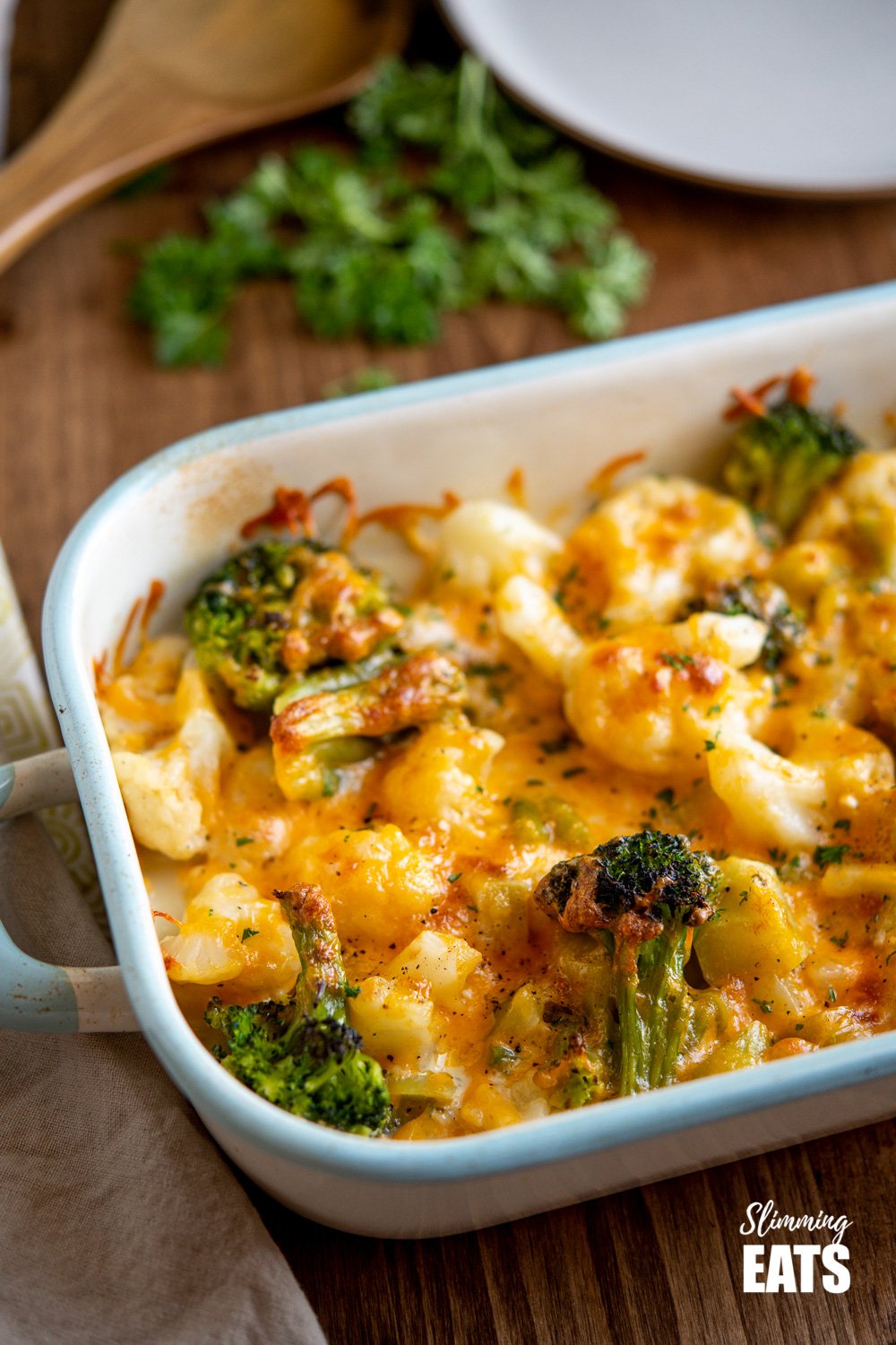  Creamy Cheesy Vegetable Bake in enamel baking dish on wooden board