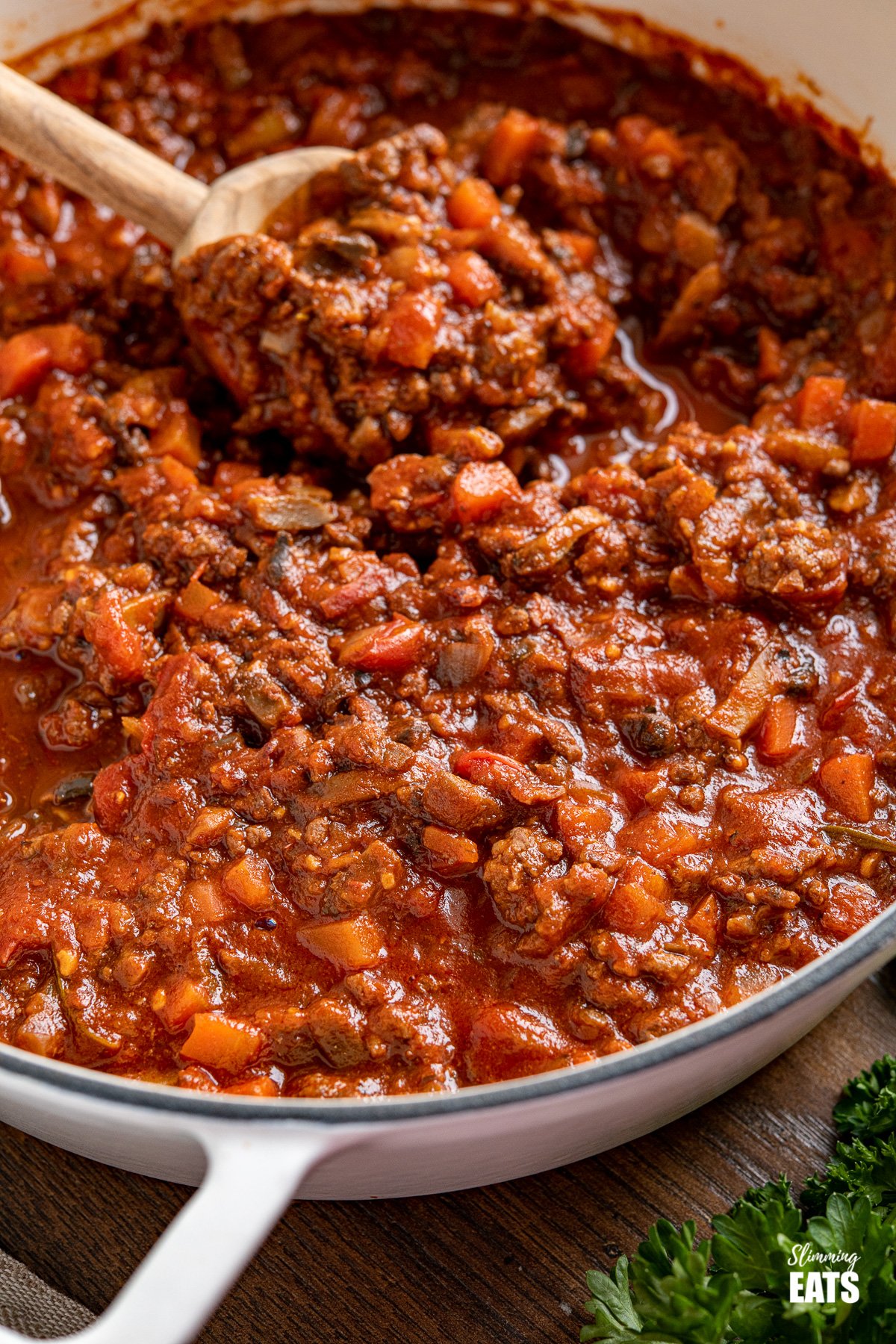 close up of Bolognese meat sauce in white cast iron casserole pan