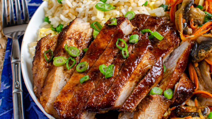 chinese pork on a plate with egg fried rice and vegetables