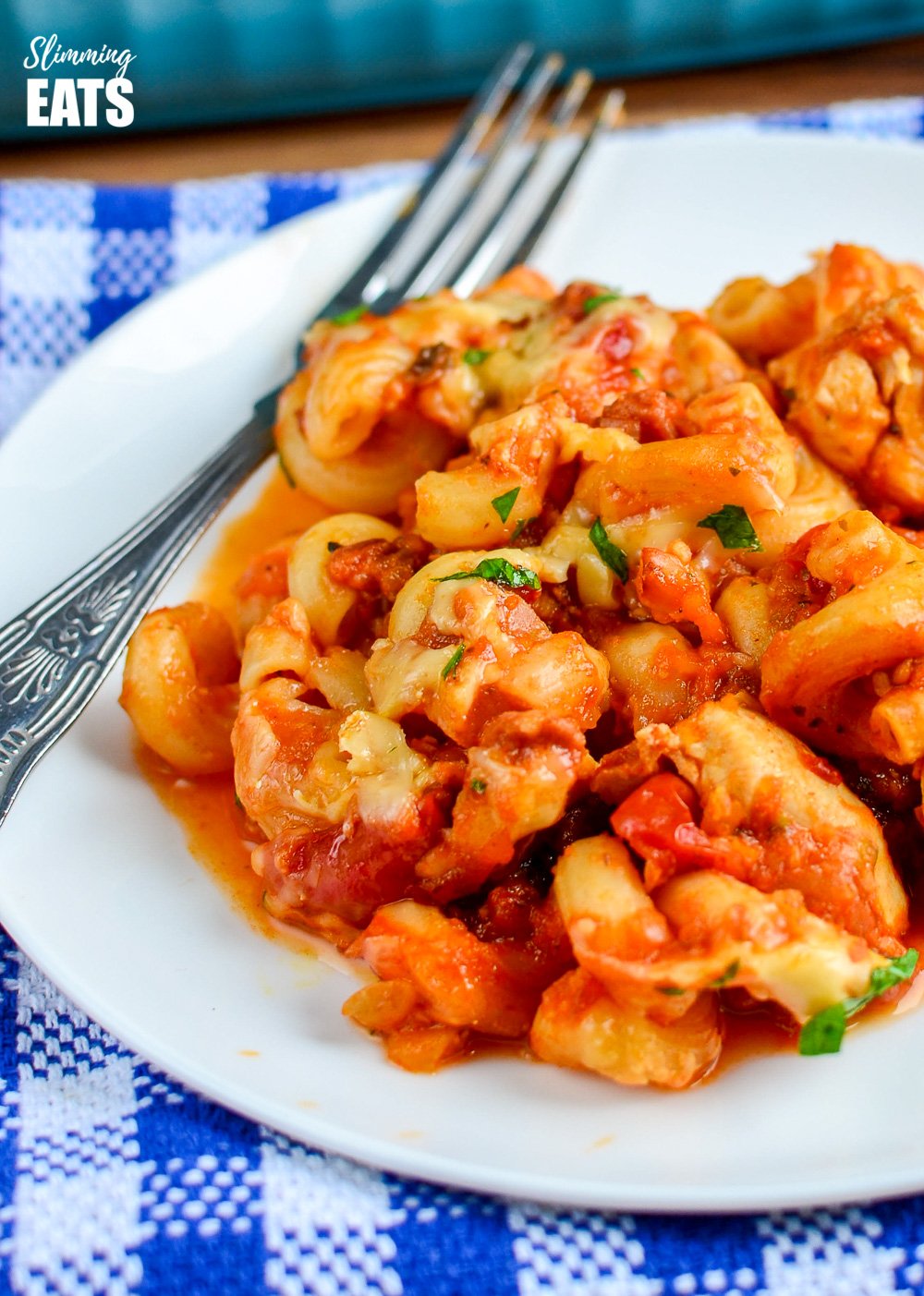 chicken bacon and tomato pasta bake on white plate with fork