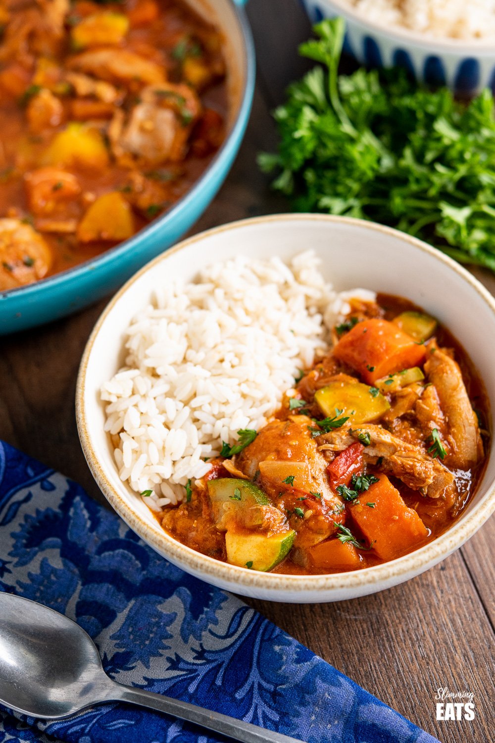 smoked paprika chicken casserole in bowl with rice on wooden board 