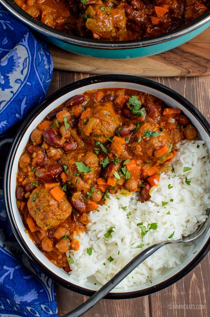 over the tip view bowl of lamb meatball and bean curry with rice with fork