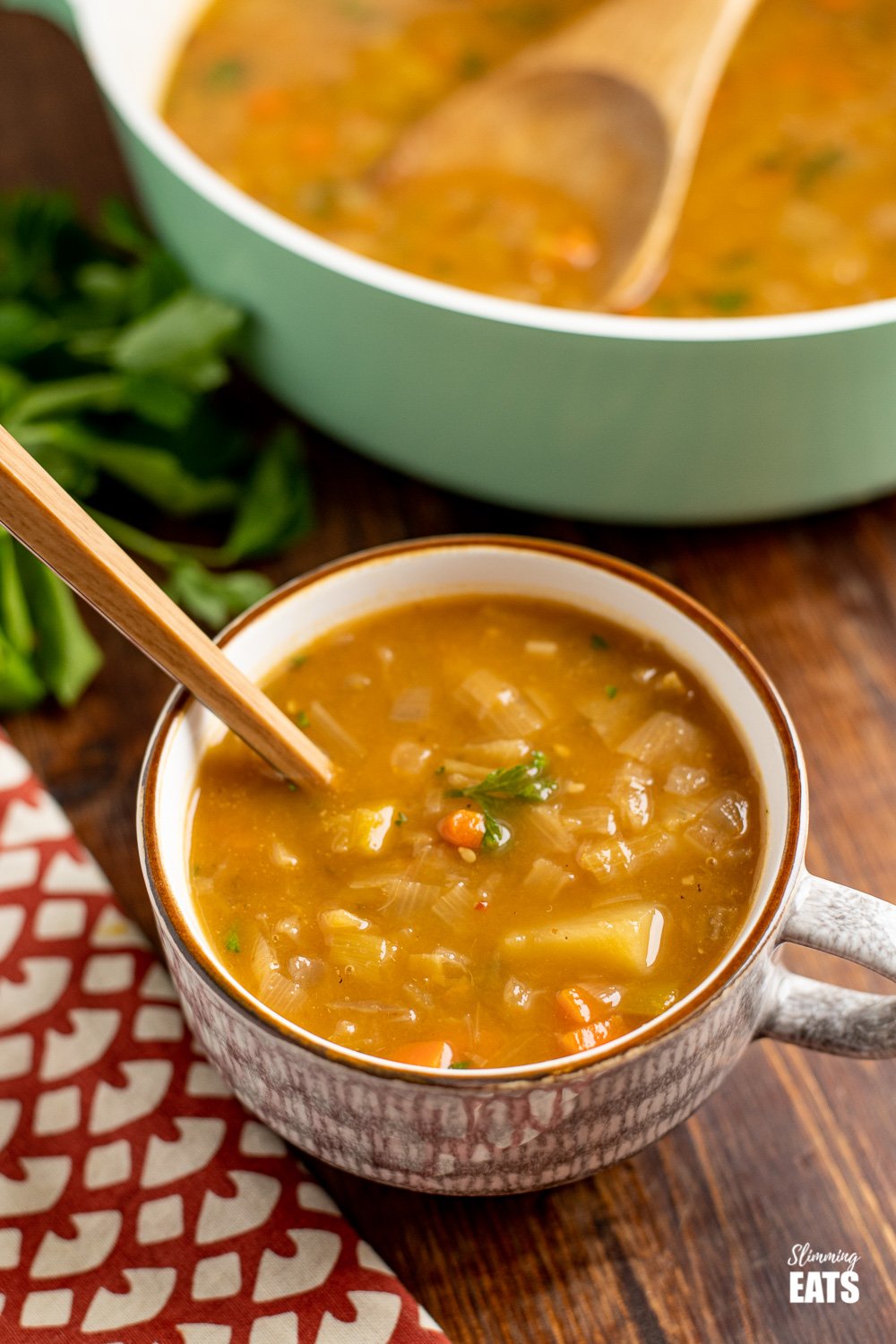 hearty vegetable soup in soup cup with spoon