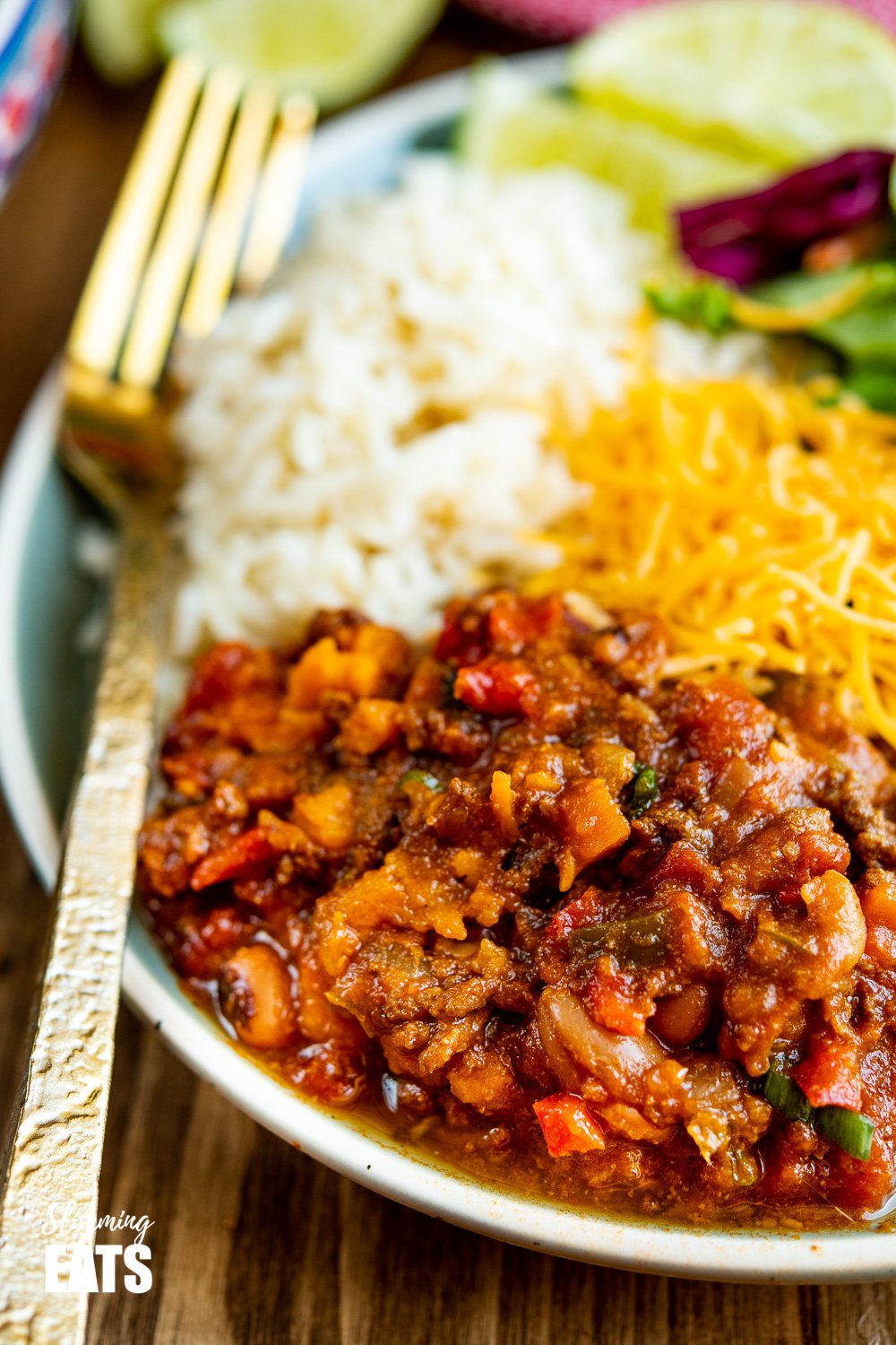 close up of beef and six bean chilli on green blue plate with gold fork