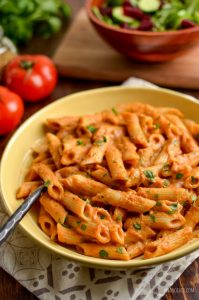 creamy tomato pasta sauce over pasta in a bowl
