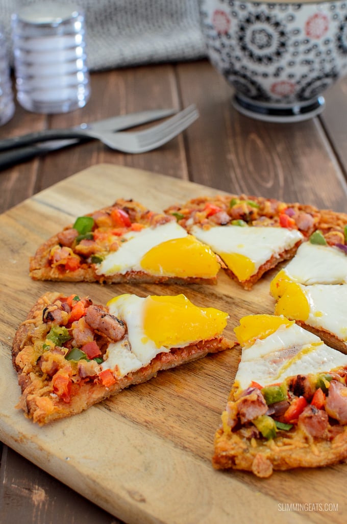 sliced breakfast hash brown pizza with coffee and knife and fork