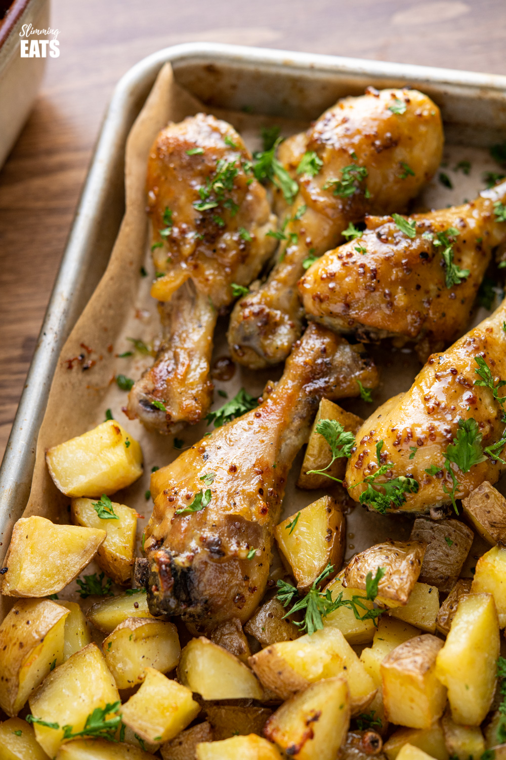 close up of honey mustard chicken drumsticks with potatoes