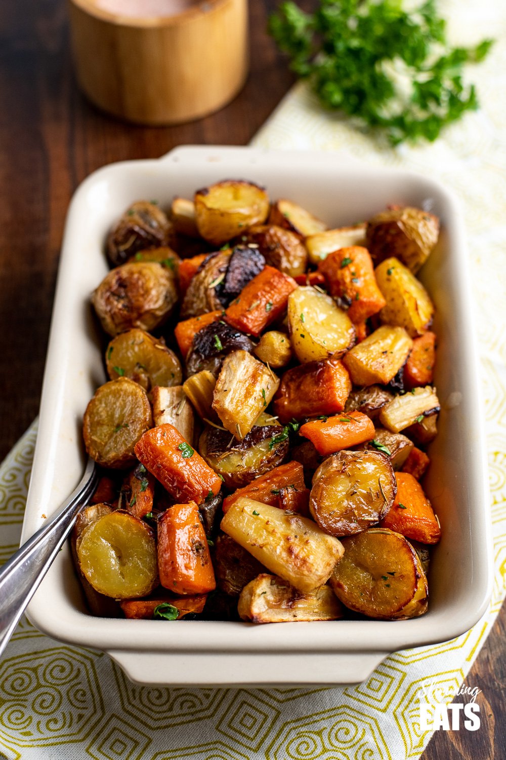 Healthy Delicious Rosemary Roasted Potatoes, Parsnips, Carrots and Onion the perfect addition to any main meal. Gluten Free, Dairy Free, Vegan, Slimming Eats and Weight Watchers friendly Rosemary Roasted Potatoes, Parsnips, Carrots and Onion in dish with metal spoon