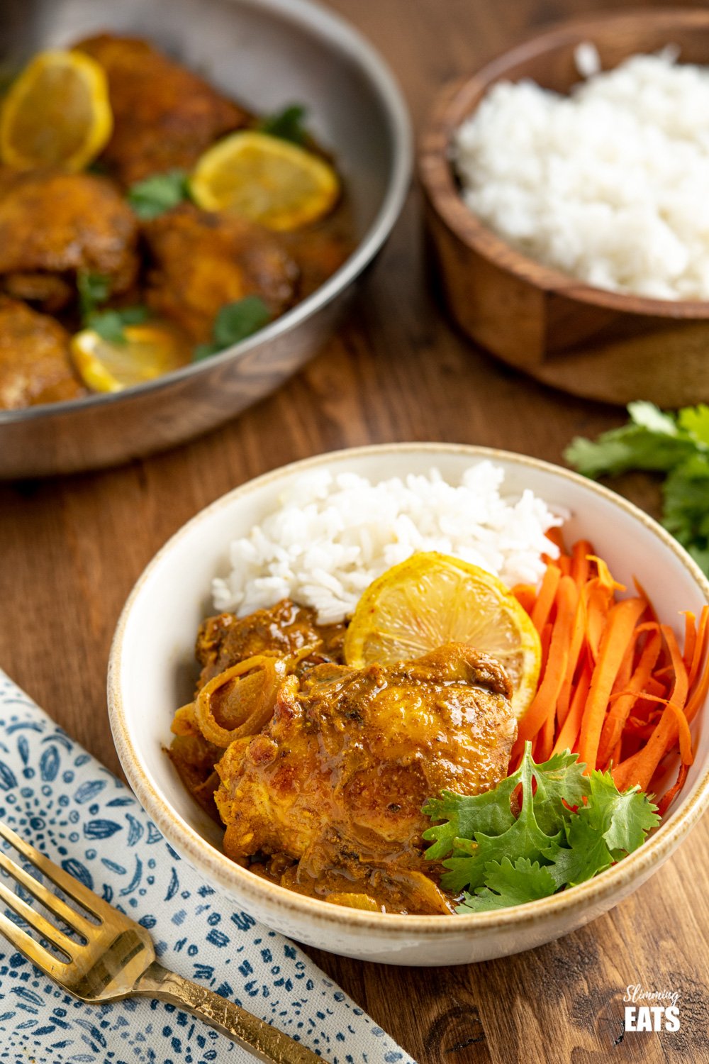 bowl of lemon chilli chicken with white rice, carrots and coriander