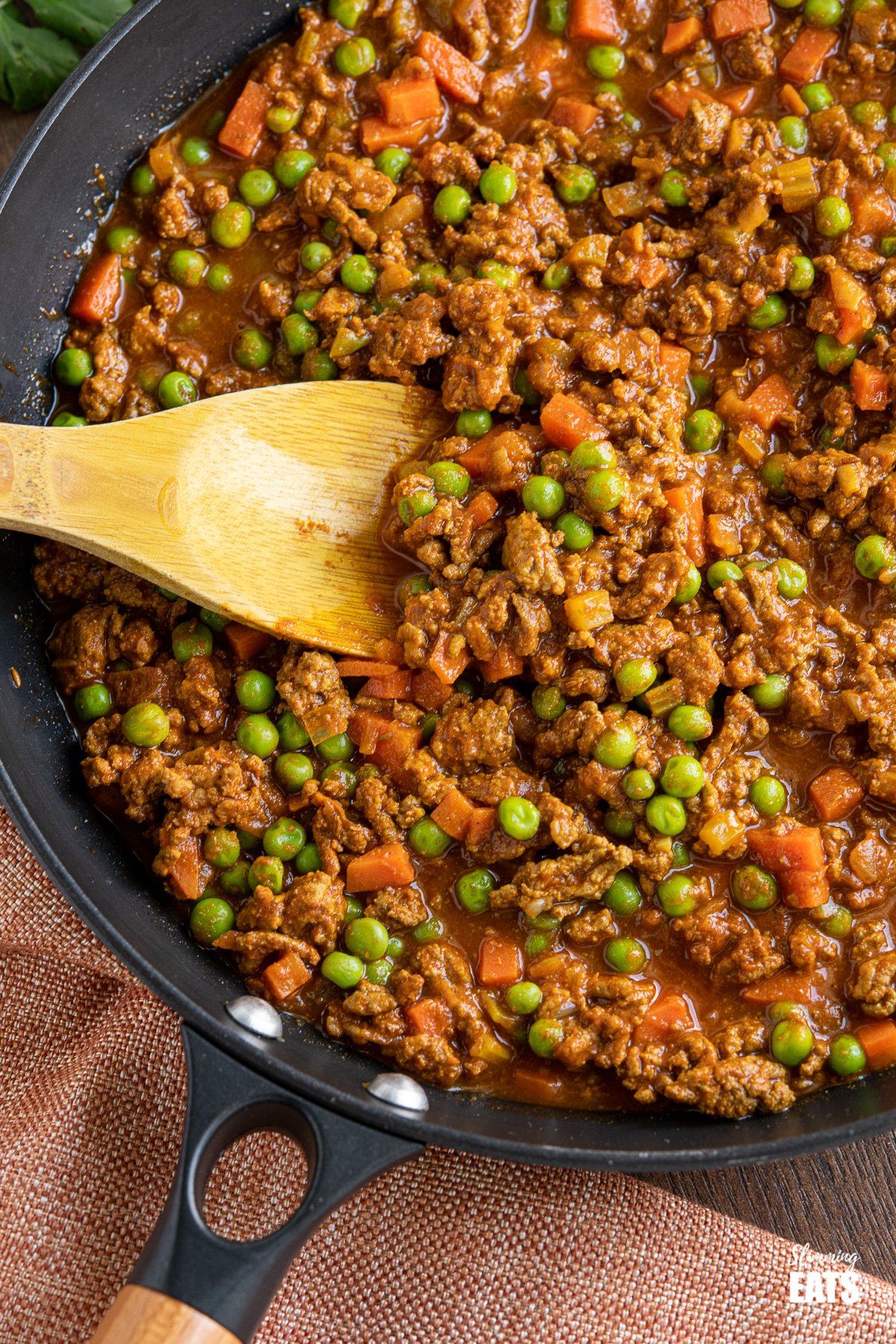 close up of Easy Keema Curry in black pan with wooden spoon