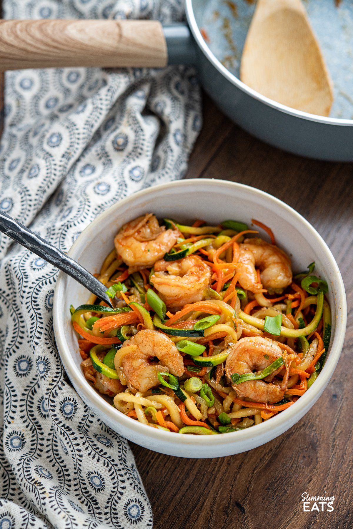 Quick Sweet Chilli Prawns with Vegetable Noodles - a quick and easy stir fry recipe that is lighter on the carbs with some healthy spiralized vegetable noodles. Slimming World and Weight Watchers friendly Quick Sweet Chilli Prawns with Vegetable Noodles in a white bowl with fork
