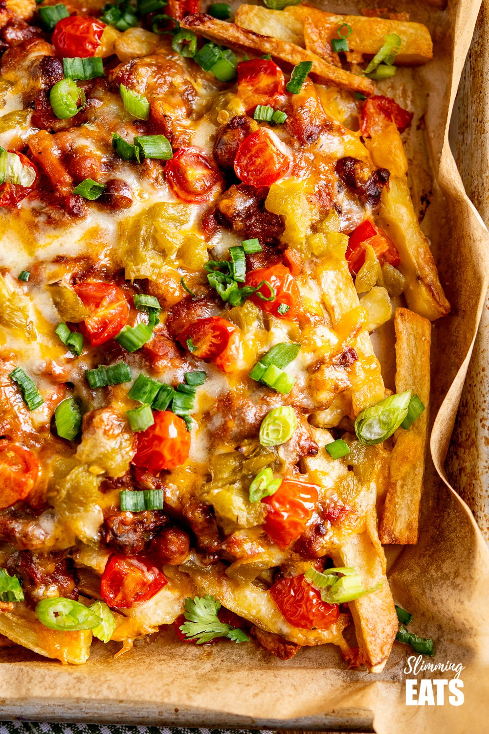 Layered Chilli Cheese Fries on parchment lined baking tray