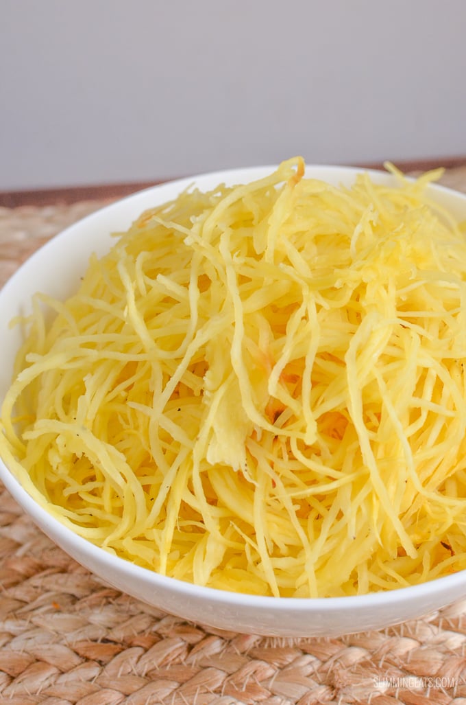 Mexican Spaghetti Squash Bake - both healthy and delicious with bold flavours, black beans and melted golden cheese. #glutenfree #vegetarian #spaghettisquash #slimmingworld #weightwatchers #bake #cheese #synfree #smartpoints white bowl of cooked spaghetti squash