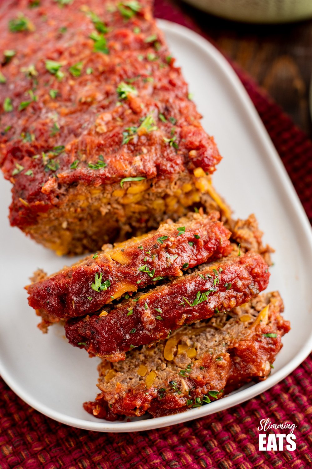 close up of sliced beef and sweet potato meatloaf on a white plate