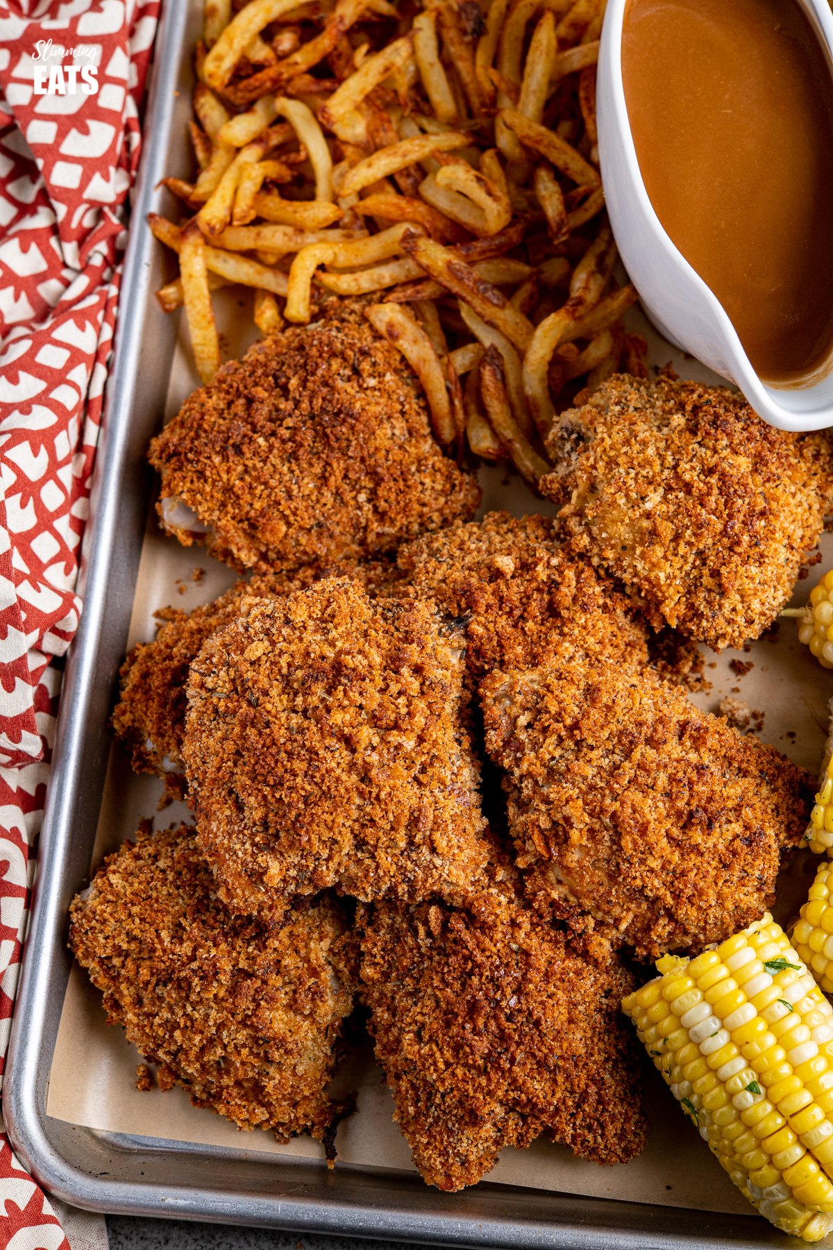  close up of oven baked kfc style chicken feast on a parchment lined baking tray