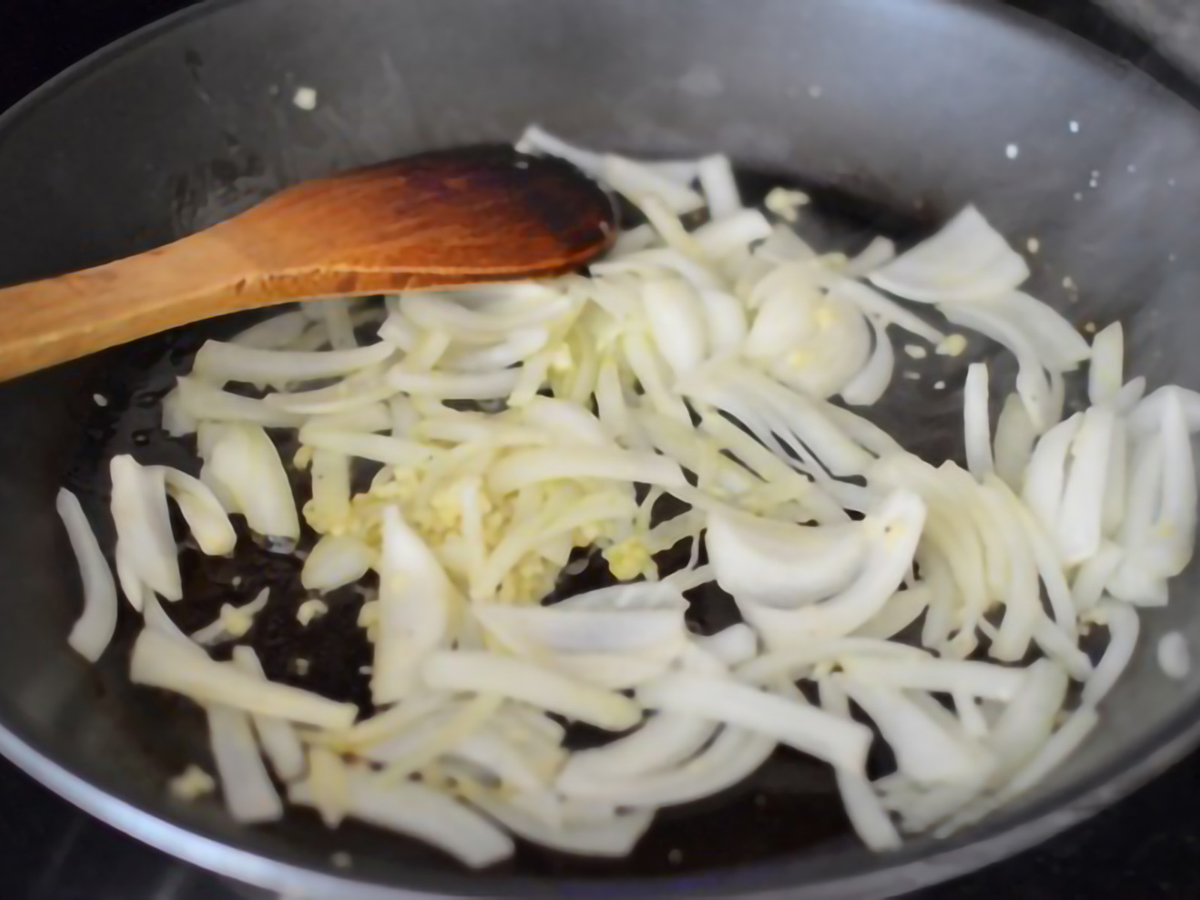 onion and garlic being sauteed in a pan