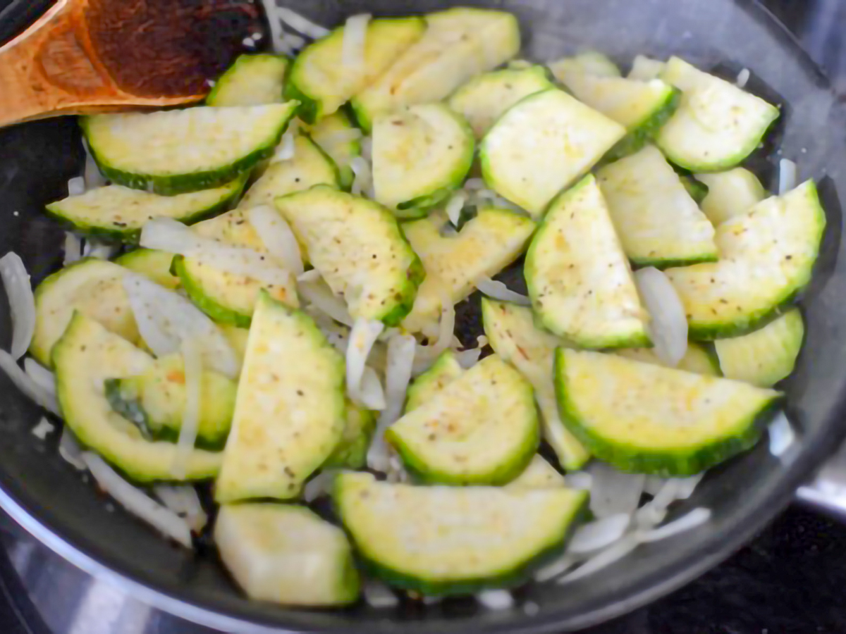 Mayan Heirloom Squash and onion and garlic being sauteed in a pan