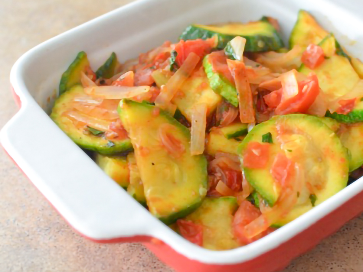 cooked Mayan Heirloom Squash with Tomatoes and Basil in a ceramic dish