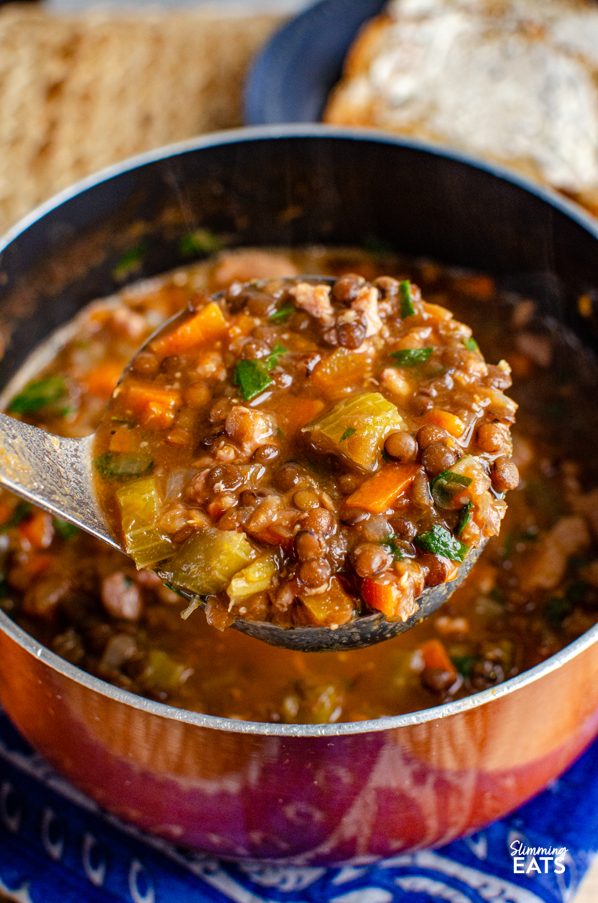 ladle spooning bacon lentil soup out of a saucepan