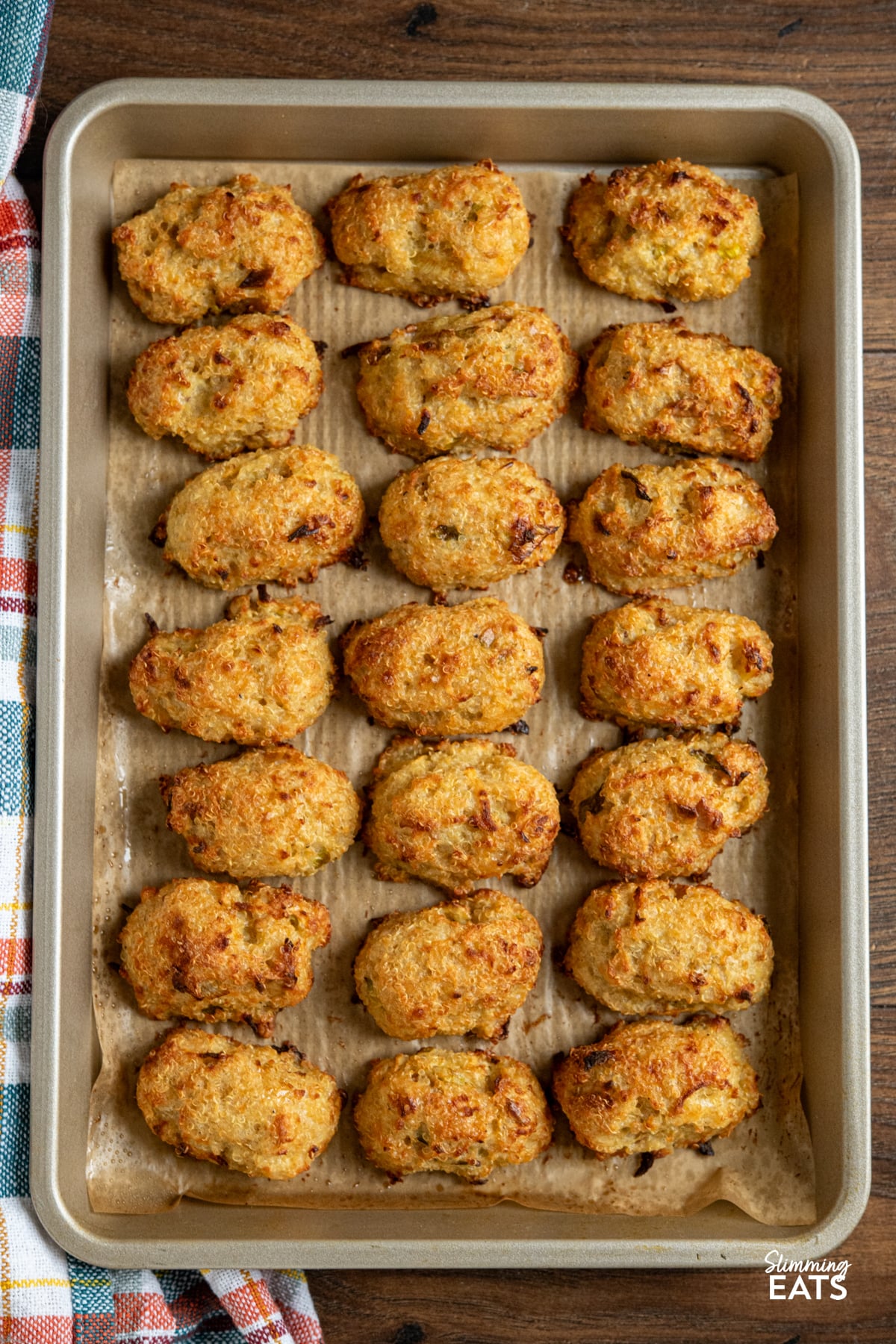 21 Cheddar Apple Quinoa Bites on a parchment lined baking tray