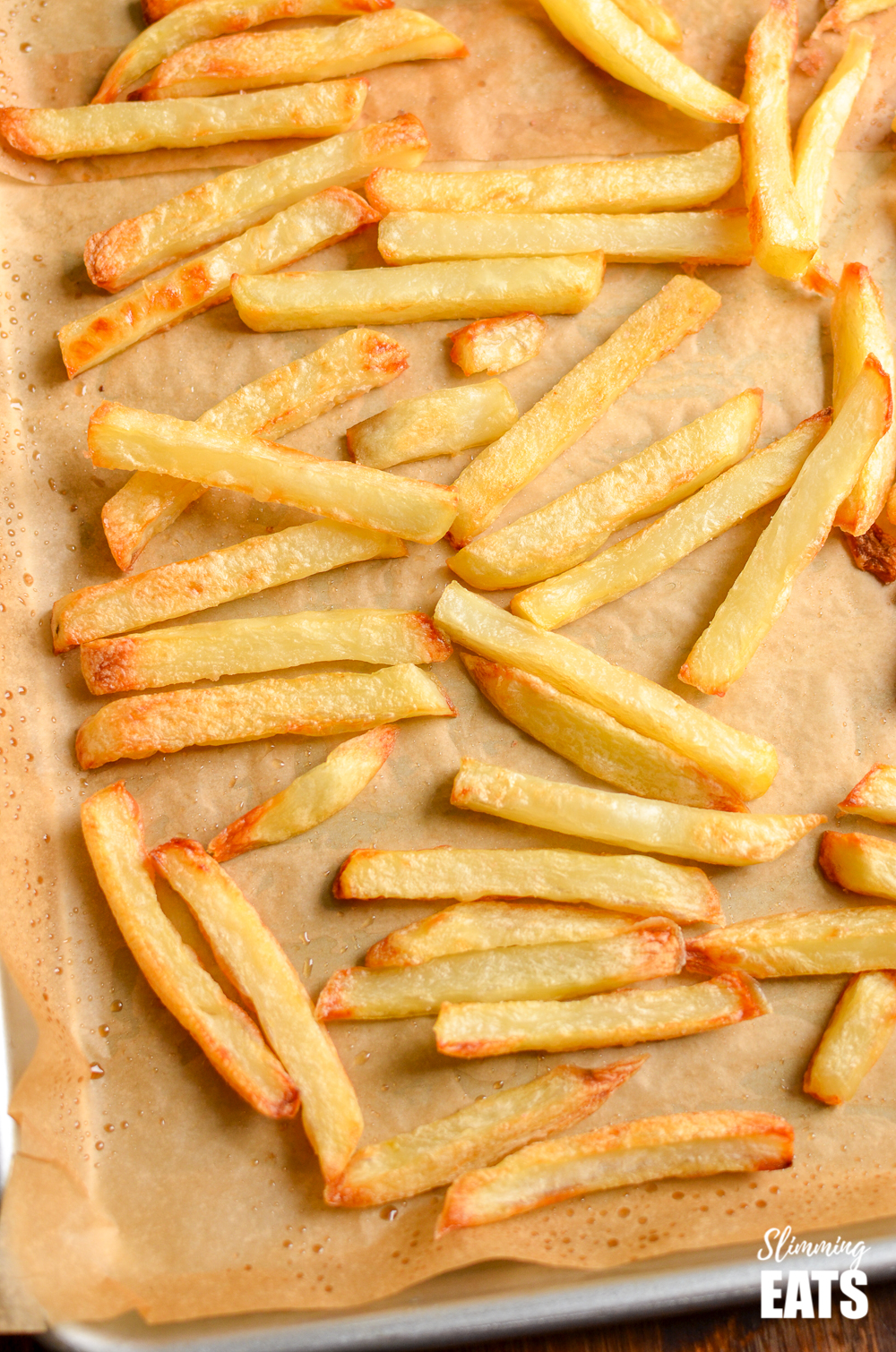 cooked perfect baked oven fries on a baking tray lined with parchment paper